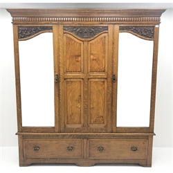 Early 20th century carved oak triple wardrobe, with two shaped mirrored doors, two drawers to base with Art Nouveau copper handles, W189cm, D50cm, H210cm