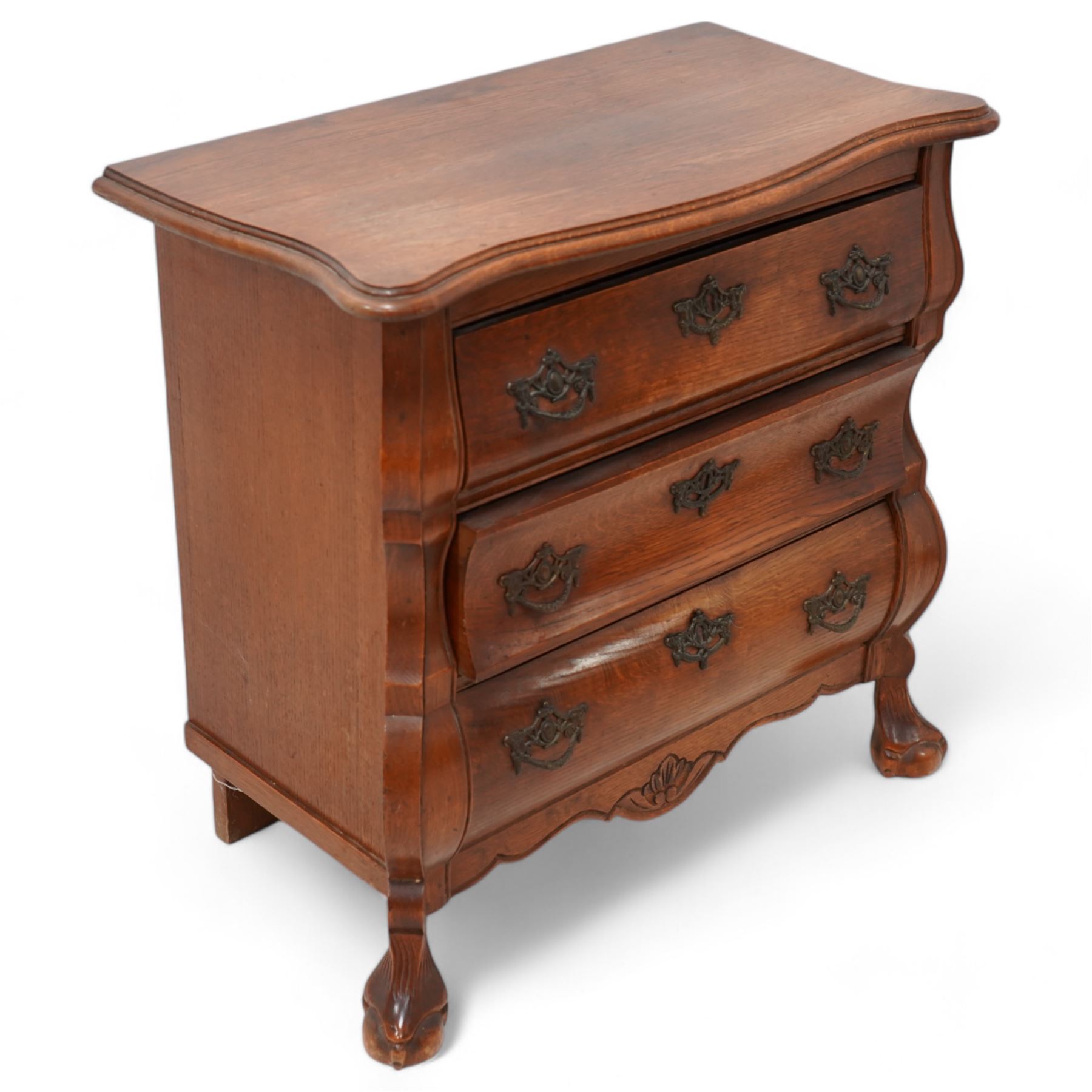 Early 20th century Dutch oak bombe chest, shaped rectangular top with moulded edge, fitted with three drawers flanked by moulded uprights, on hairy ball-and-claw feet