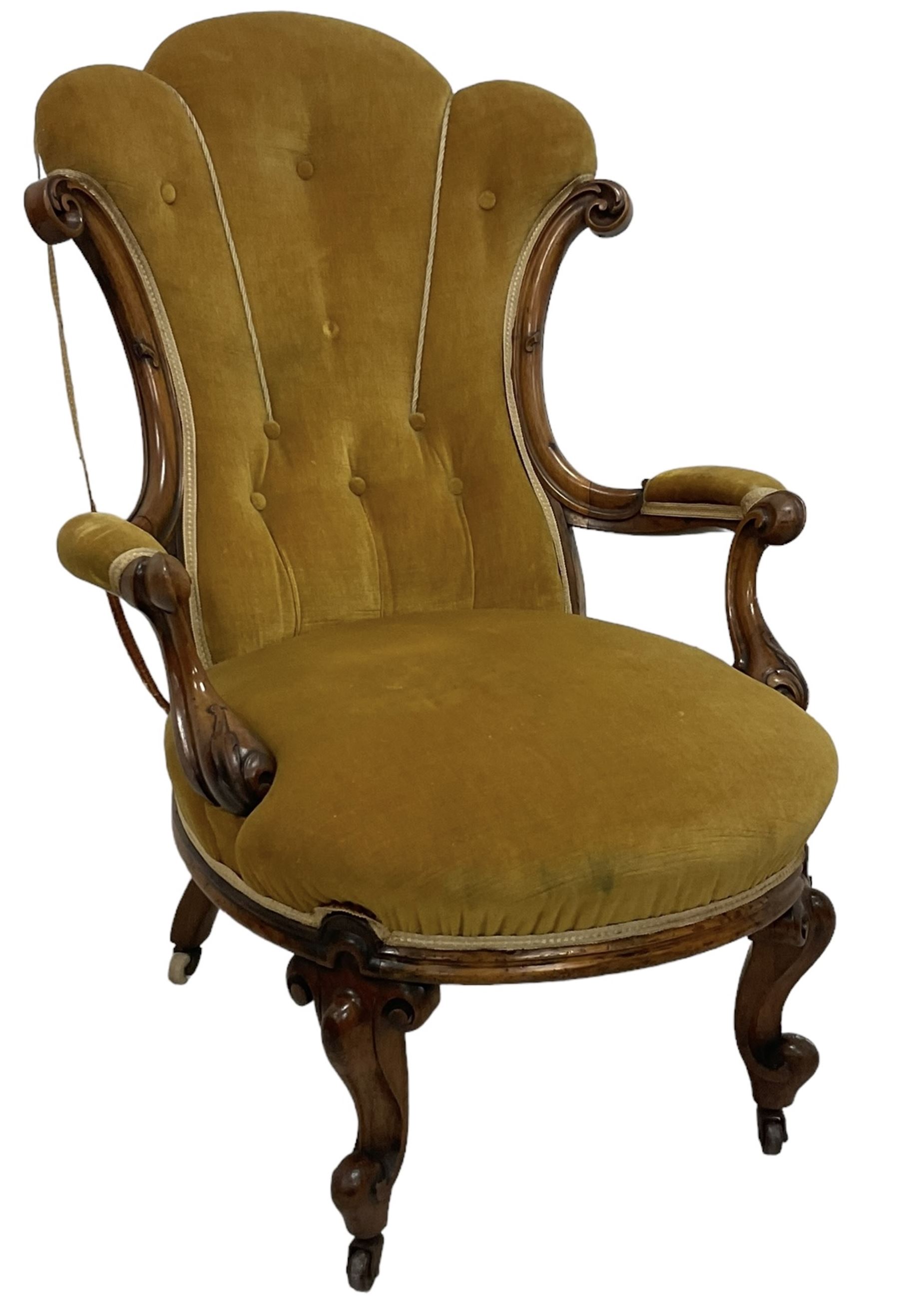 19th century walnut framed open armchair, scallop shaped back with c-scroll uprights, upholstered in yellow buttoned velvet fabric with sprung seat, arm terminals carved with acanthus leaves, raised on scrolling cabriole supports with castors