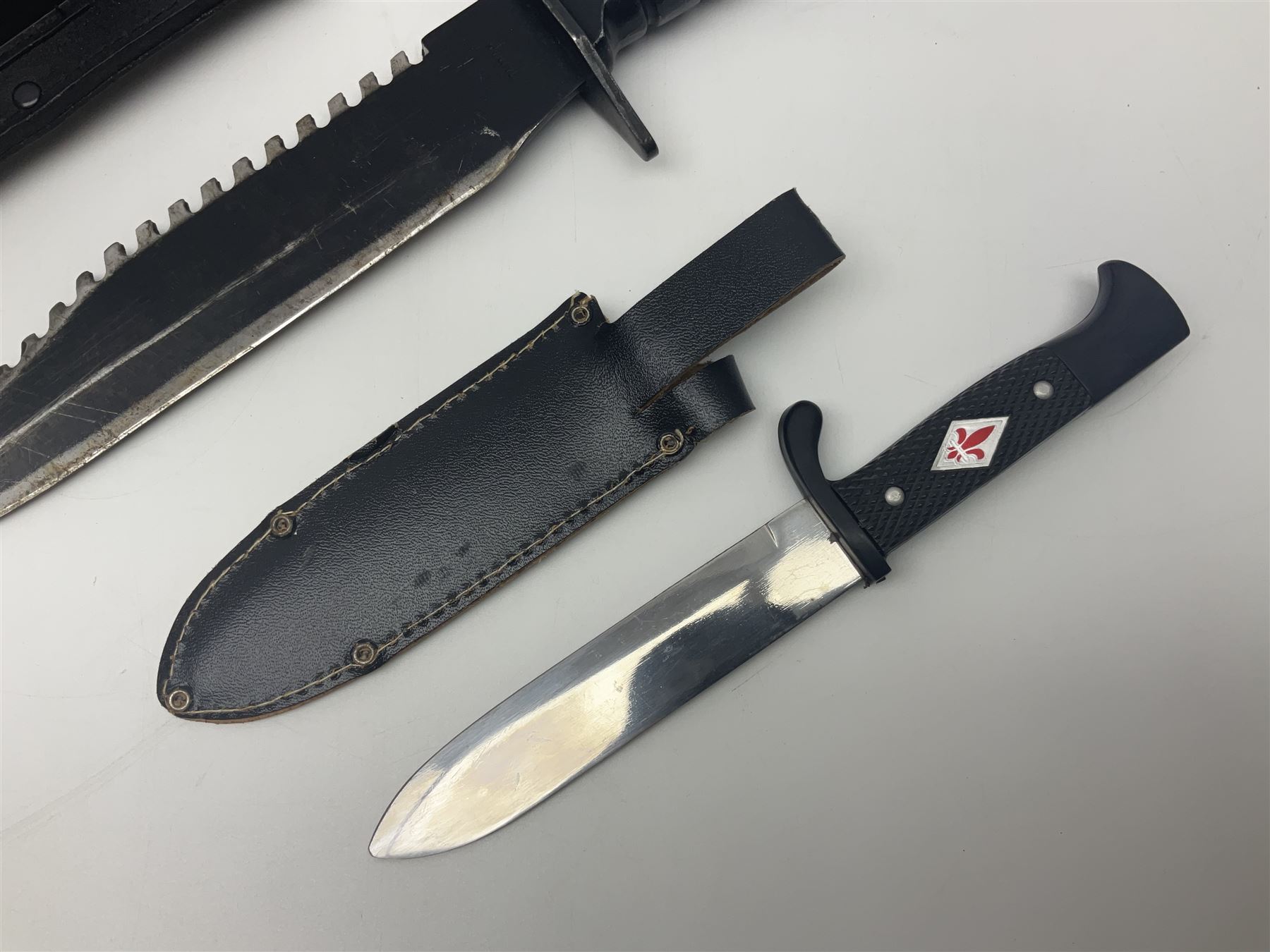 Post WWII scout knife, based on a Hitler Youth knife, in embossed leather sheath with scout emblem to handle, together with a similar example, also with scout emblem to handle, marked Whitby made in Germany, and a hunting knife with serrated edge, largest L39cm