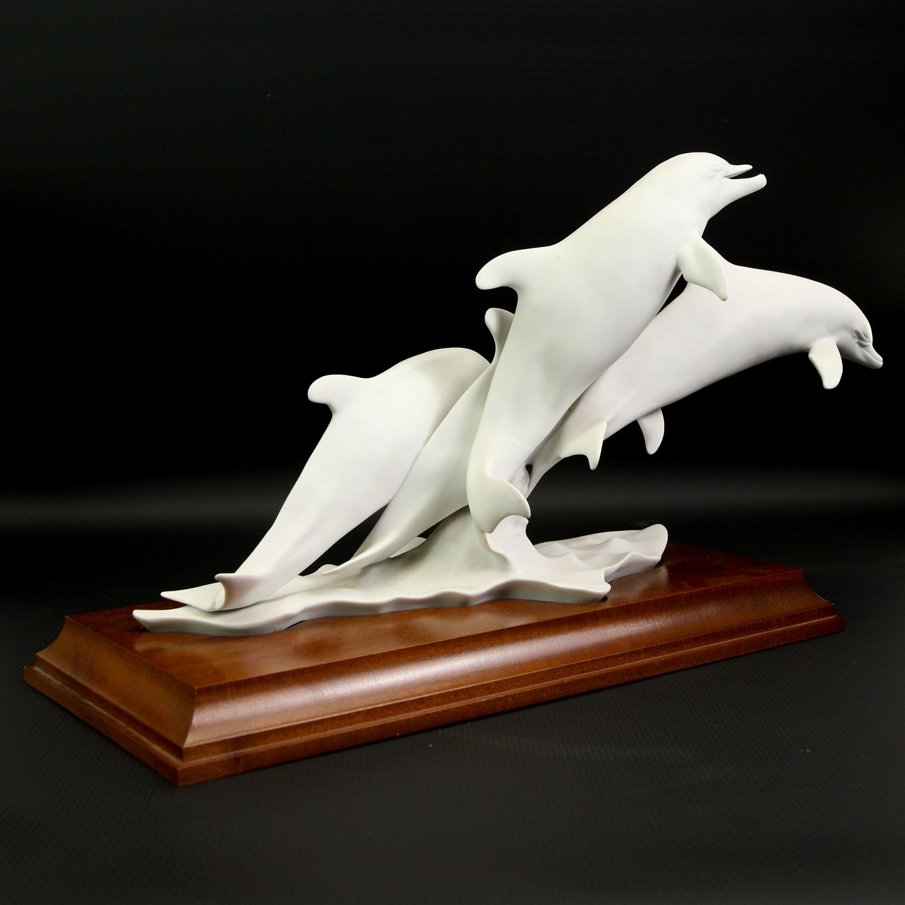 Kaiser limited edition porcelain group of four bottlenose dolphins on wooden stand No.306/4500 with incised signature W40cm and a Kaiser vase No.618 with incised signature to base H28cm (2)