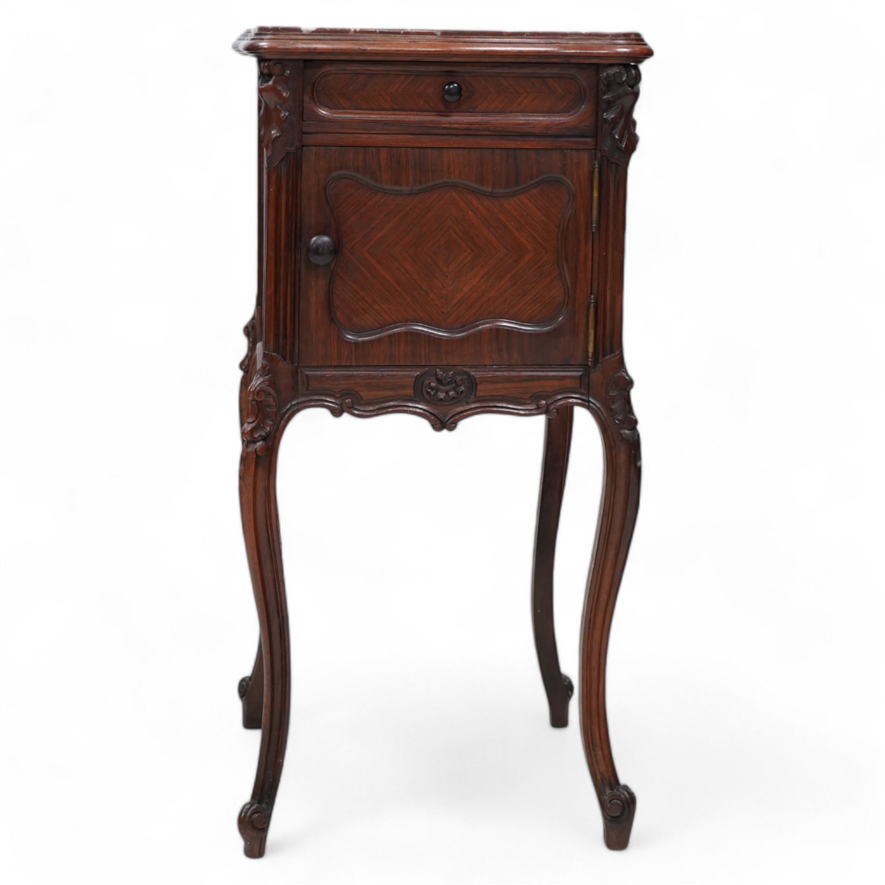 Early 20th century walnut bedside pot cupboard, shaped variegated rouge marble top within moulded frame, single drawer over single cupboard, the interior lined with white marble, cartouche carved cabriole supports with scrolled terminals 