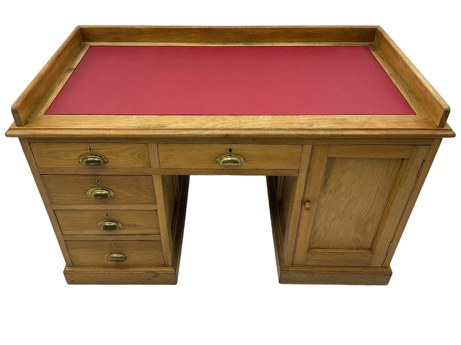 20th century oak desk, moulded rectangular top with raised back and inset leather writing surface, fitted with five drawers and single panelled cupboard, on moulded plinth base