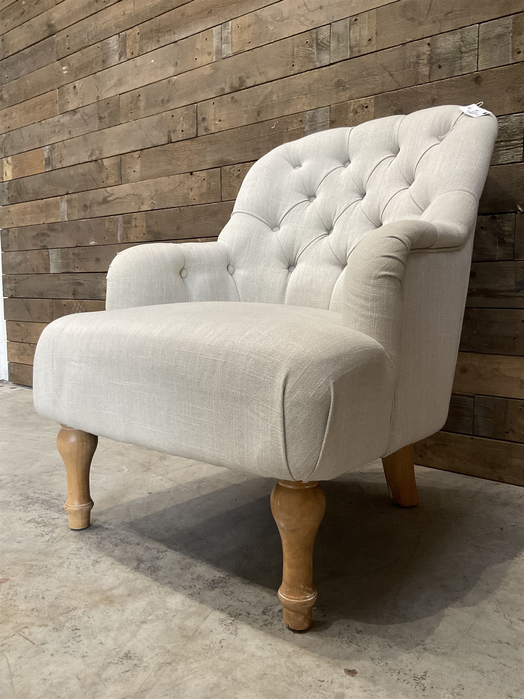 Armchair upholstered in button back linen fabric