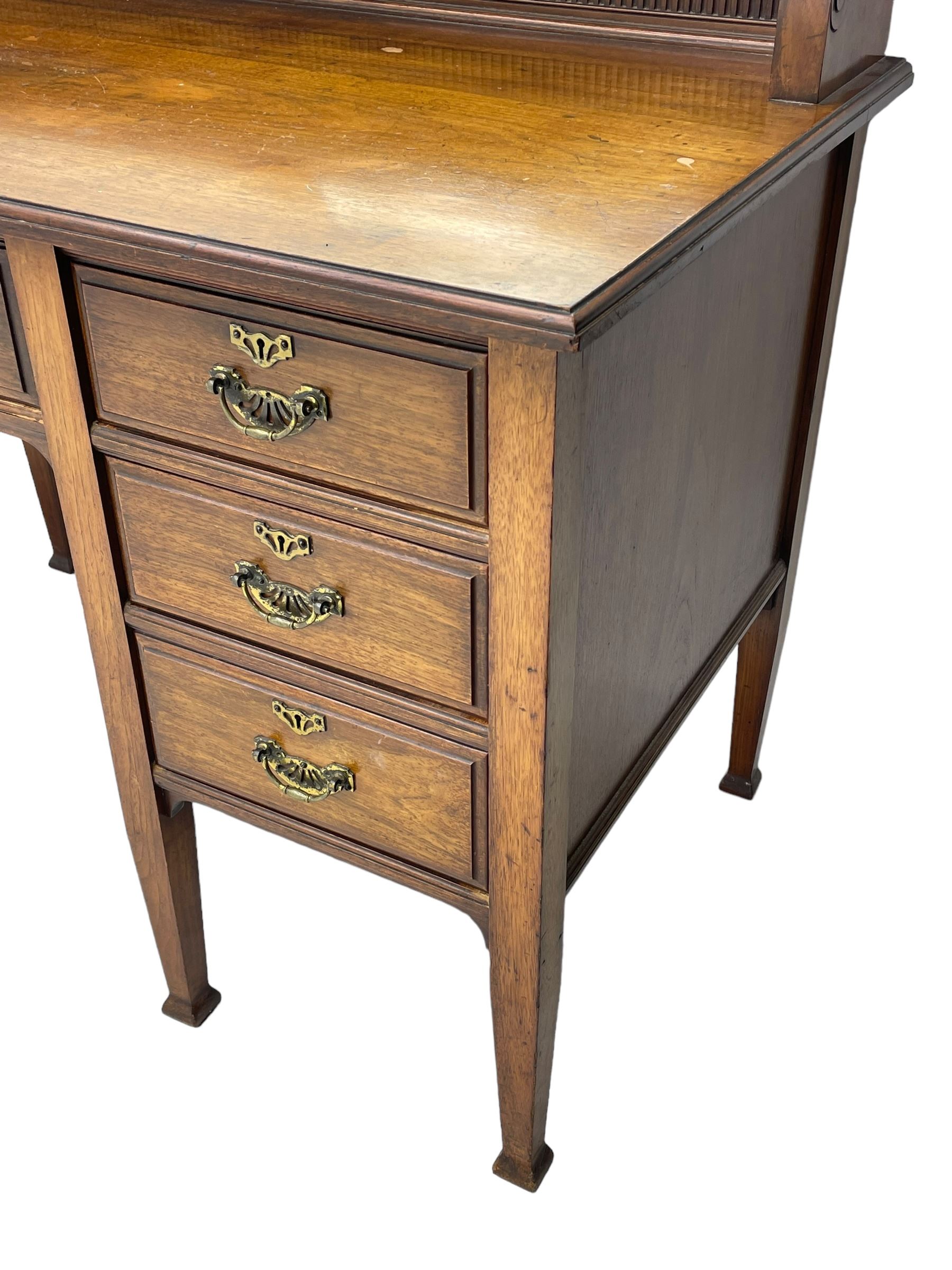 Late 19th century walnut dressing table, wide rectangular bevelled swing mirror in moulded frame, shaped horns carved with scrolls, moulded rectangular top over seven drawers, on square tapering supports with spade feet 