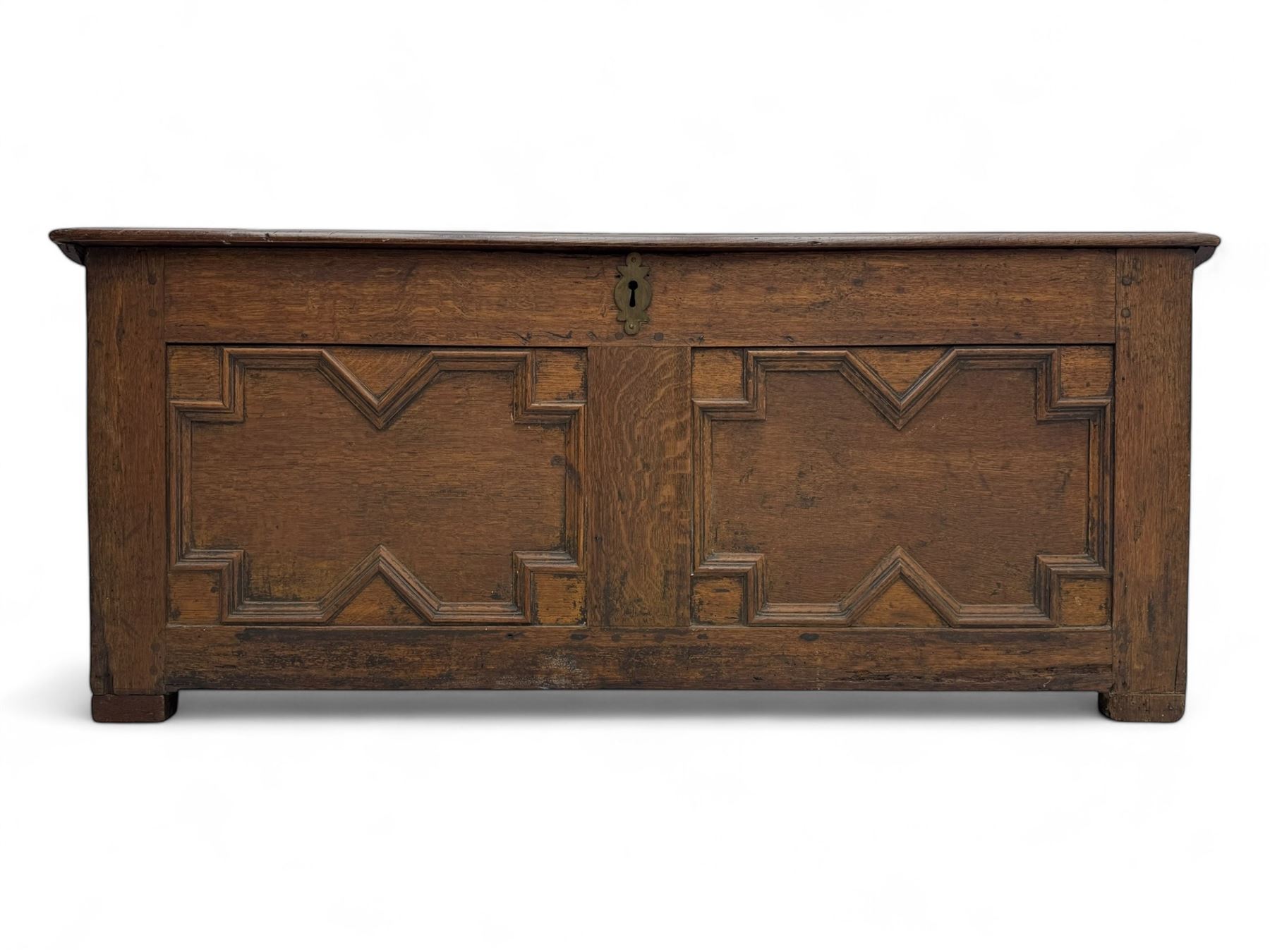 18th century oak blanket box, rectangular form with a hinged lid, the front decorated with raised geometric panelled mouldings, fitted with a central lock plate, raised on bracket feet