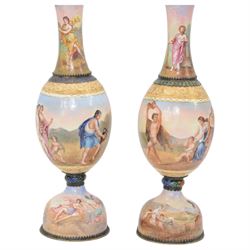 Pair of late 19th century Austrian silver and enamel vases by Hermann Böhm, of baluster form, overall decorated the top depicting musical scenes and oratory with reclining figures in togas, the ovoid bodies painted with Dithyramb scenes portraying Dionysiac worshippers playing the cymbals, pan pipes and lyre, with a dancing Maenad bearing a Thyrsus beside, and surrounding figures consuming wine, the domed pedestal feet depicting the Greek gods observing from the clouds with Putti, and recovering a lost statue from ploughed fields, within foliate silver mounts, marked A for Vienna and maker's mark HB, H21cm (2)