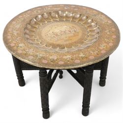 Early 20th century brass and hardwood Benares table, circular brass top with dished centre...