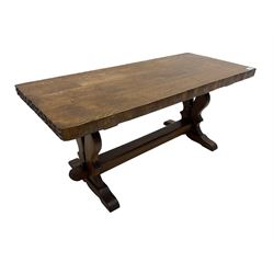 Solid oak coffee table, rectangular waved cut top with tooled ends, on shaped and pierced end supports joined by pegged stretcher 