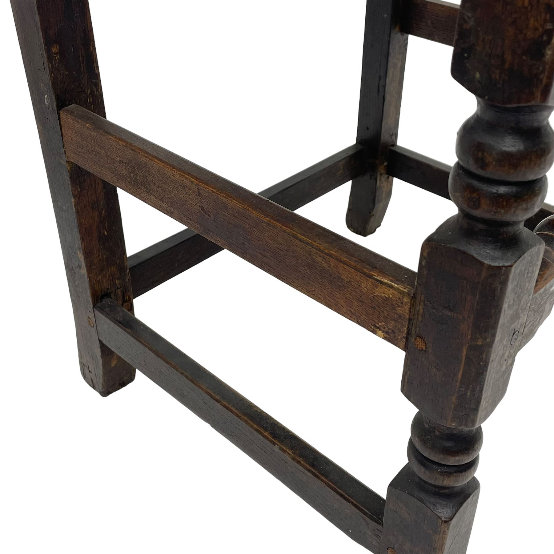 Set of three 18th century carved oak back stools, the cresting rail carved with scrolling foliate motifs over an arched panel with a stylised tree carving with extending leafage, the panelled seat held within a bobbin-turned frame, raised on turned supports united by a ring-turned front stretcher