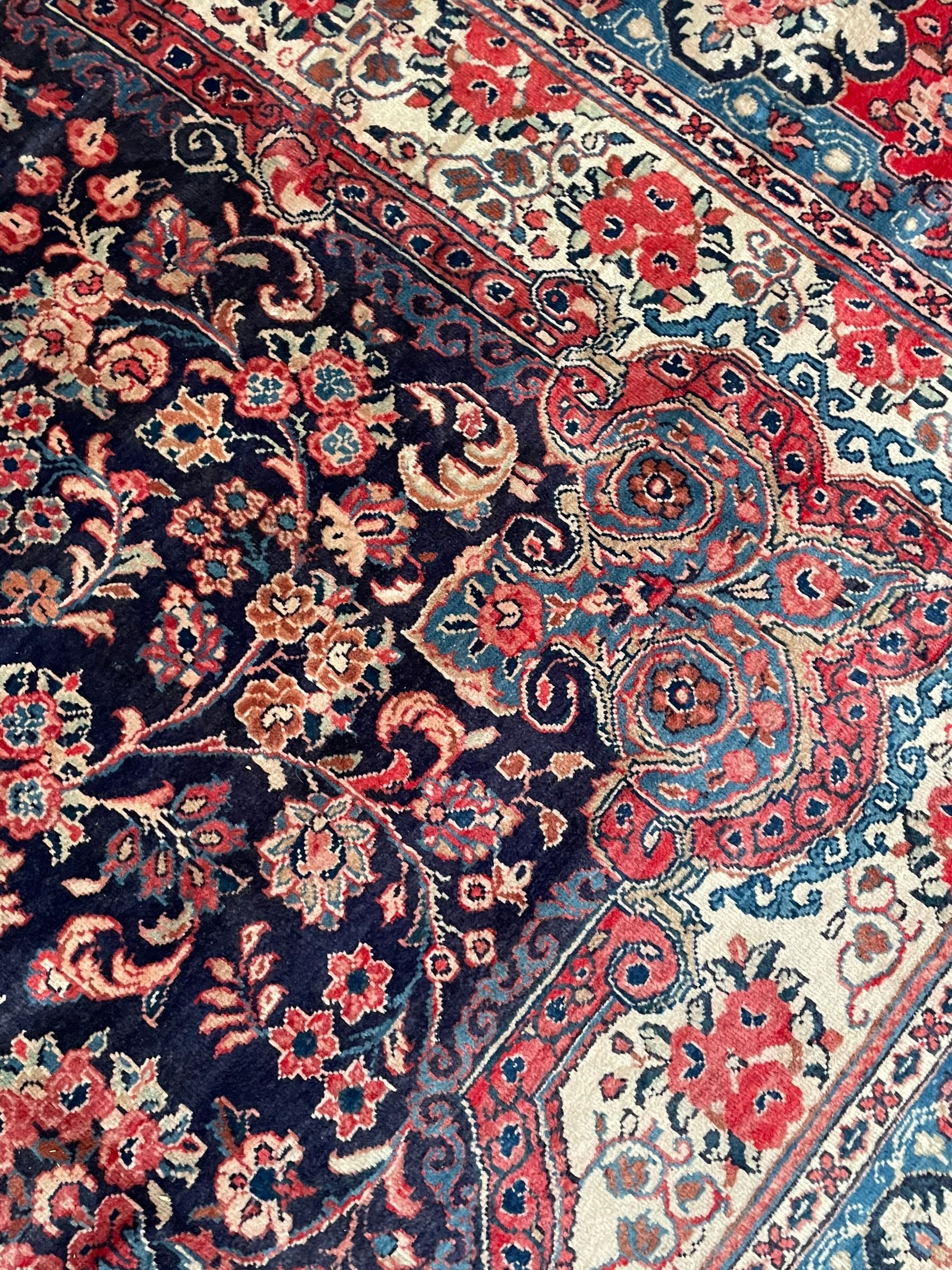 Persian Mahal indigo ground carpet, floral medallion on a field of swirling leafy branches and flower heads, shaped ivory field band decorated with flower head bouquets and trailing branches, the border decorated with floral motifs, within guard stripes