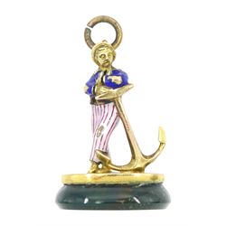 Early 20th century 18ct gold sailor and anchor pendant, the enamelled figure stood on a bl...