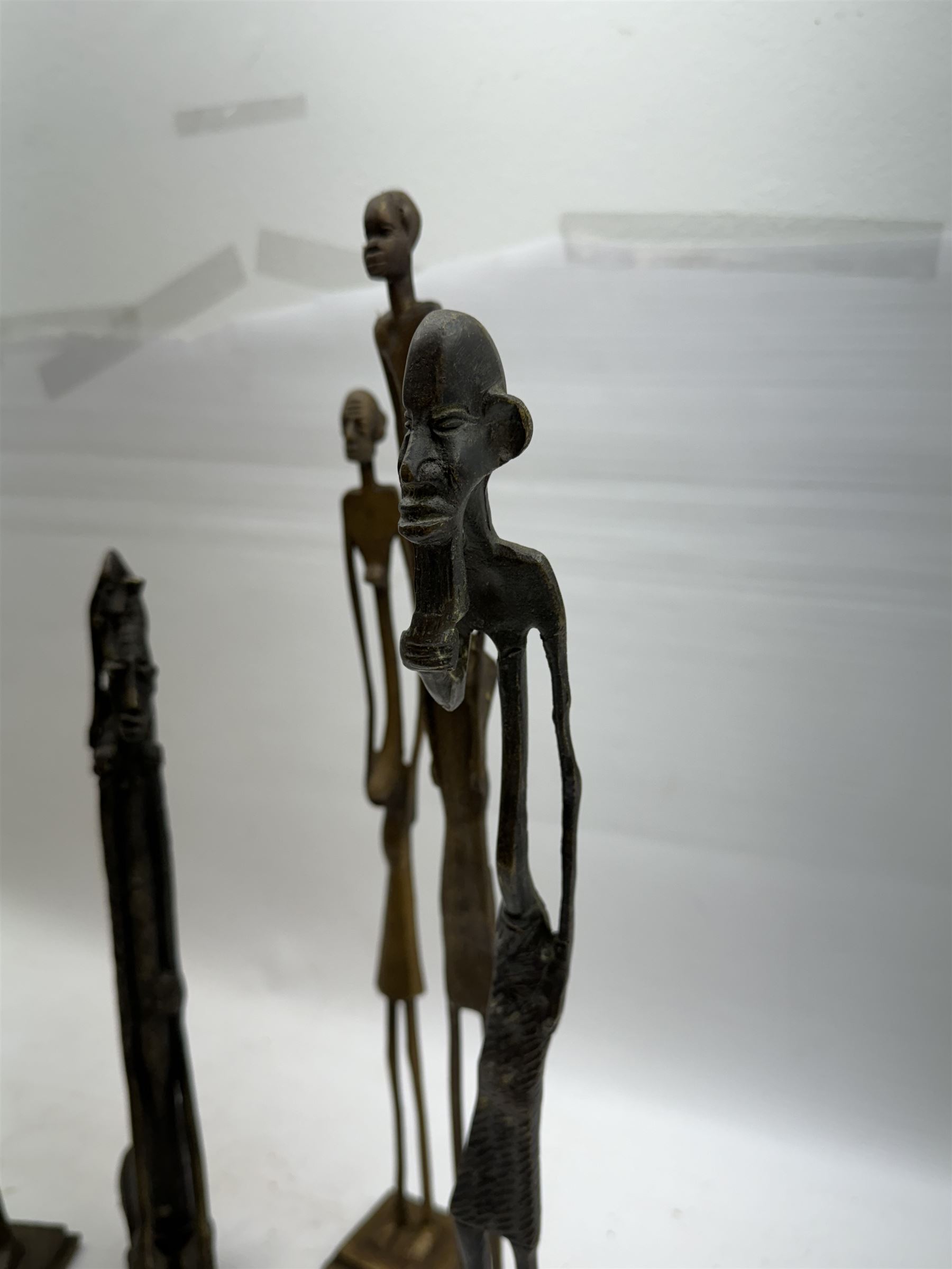 Five bronzed tribal figures, of elongated form, tallest H18cm