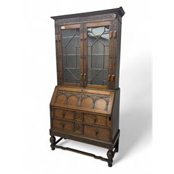 Early 20th century oak bureau bookcase, projecting moulded cornice over floral-carved frie...