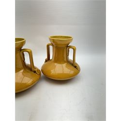 Christopher Dresser for Linthorpe Pottery, pair of twin handled vases, ochre glaze, H14cm