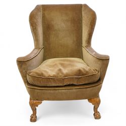 Early 20th century walnut framed wingback armchair, shallow wing back over wide seat with outward rolled arms, curved seat rail, on shell carved ball and claw cabriole feet 