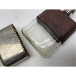 Silver plated glass and pressed leather hip flask, with swivel cap and removable cup, together with a similar oval example, engraved with wreath and initial B, tallest H16.5cm