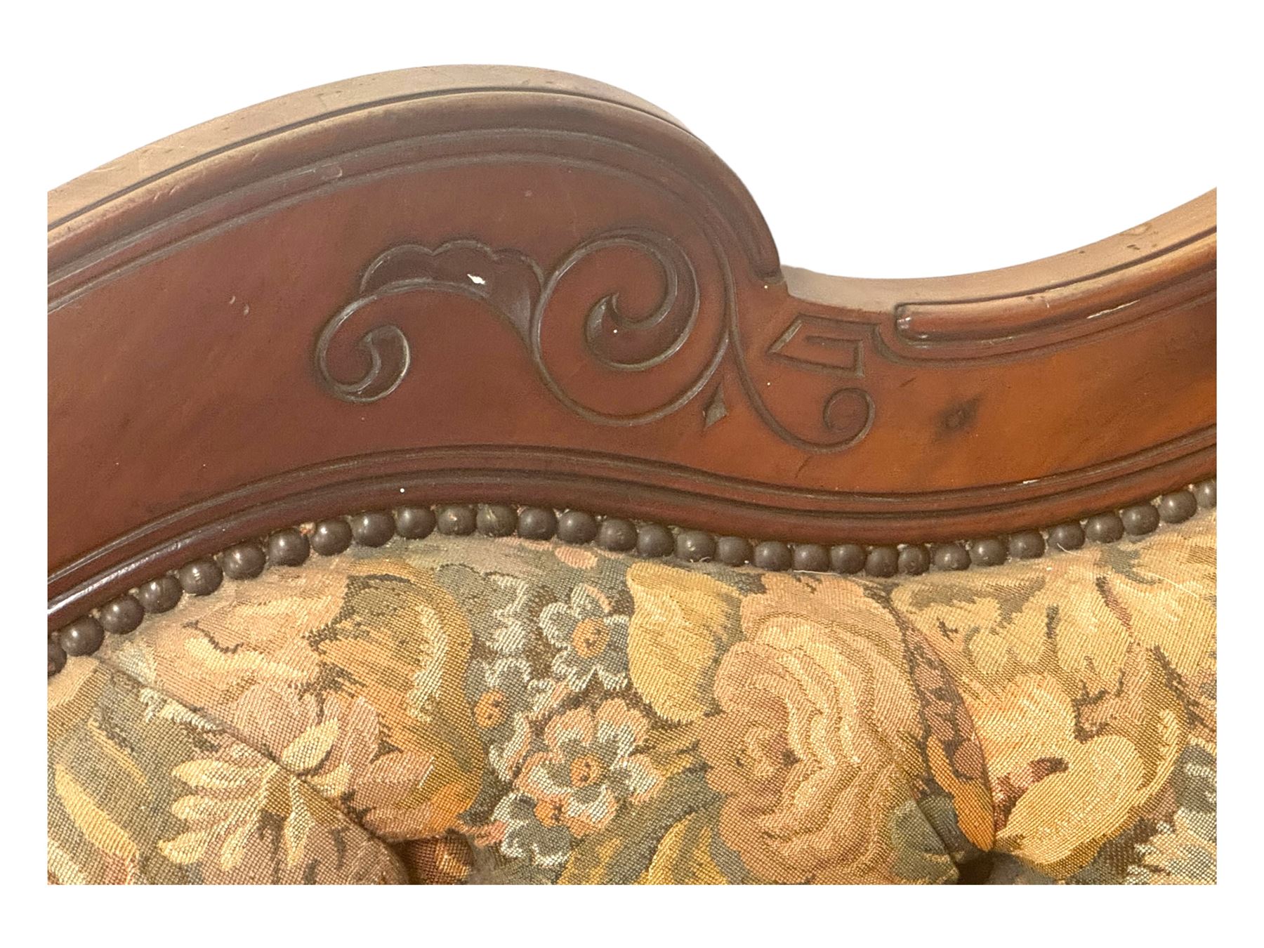 Victorian Aesthetic Movement mahogany framed chaise longue, shaped carved back over acanthus scrolled arm terminal, upholstered in floral patterned tapestry fabric with sprung seat, on turned and fluted supports with castors