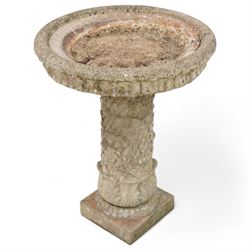 Composite stone two-piece bird bath, circular dished top with leaf decorated edge, on twis...