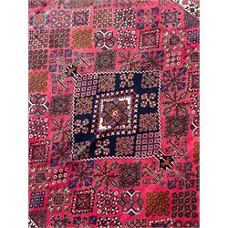 Persian Joshaghan red ground rug, the medallion, field and spandrels decorated with Pitrak and tree of life motifs, the border with repeating design decorated with stylised plant motifs, within guard stripes