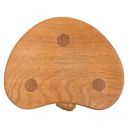 Rabbitman -  oak milking stool, dished kidney shaped top, on three tapered octagonal supports, carved with rabbit signature, by Peter Heap, Wetwang