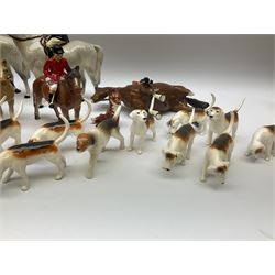 Beswick Hunting Group, comprising: two huntswoman on grey horses, model no 1730, huntsman on a bay horse, model no 1501, a seated fox, model no 1748, eighteen fox hounds and a spaniel, model no 967, all with printed marks beneath, together with three other ceramic huntsman on horseback and two hounds. 