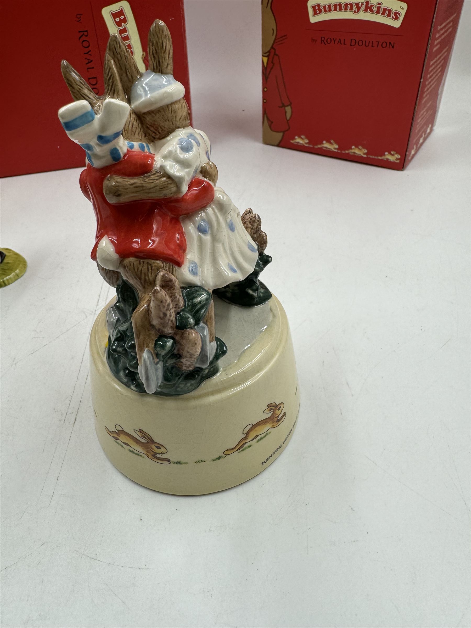 Two Royal Doulton Bunnykins music boxes, comprising Rocking Horse and Winter Waltz together with two Royal Doulton Bunnykins figures Once Upon a Time and Father, Mother & Victoria, all with original boxes  