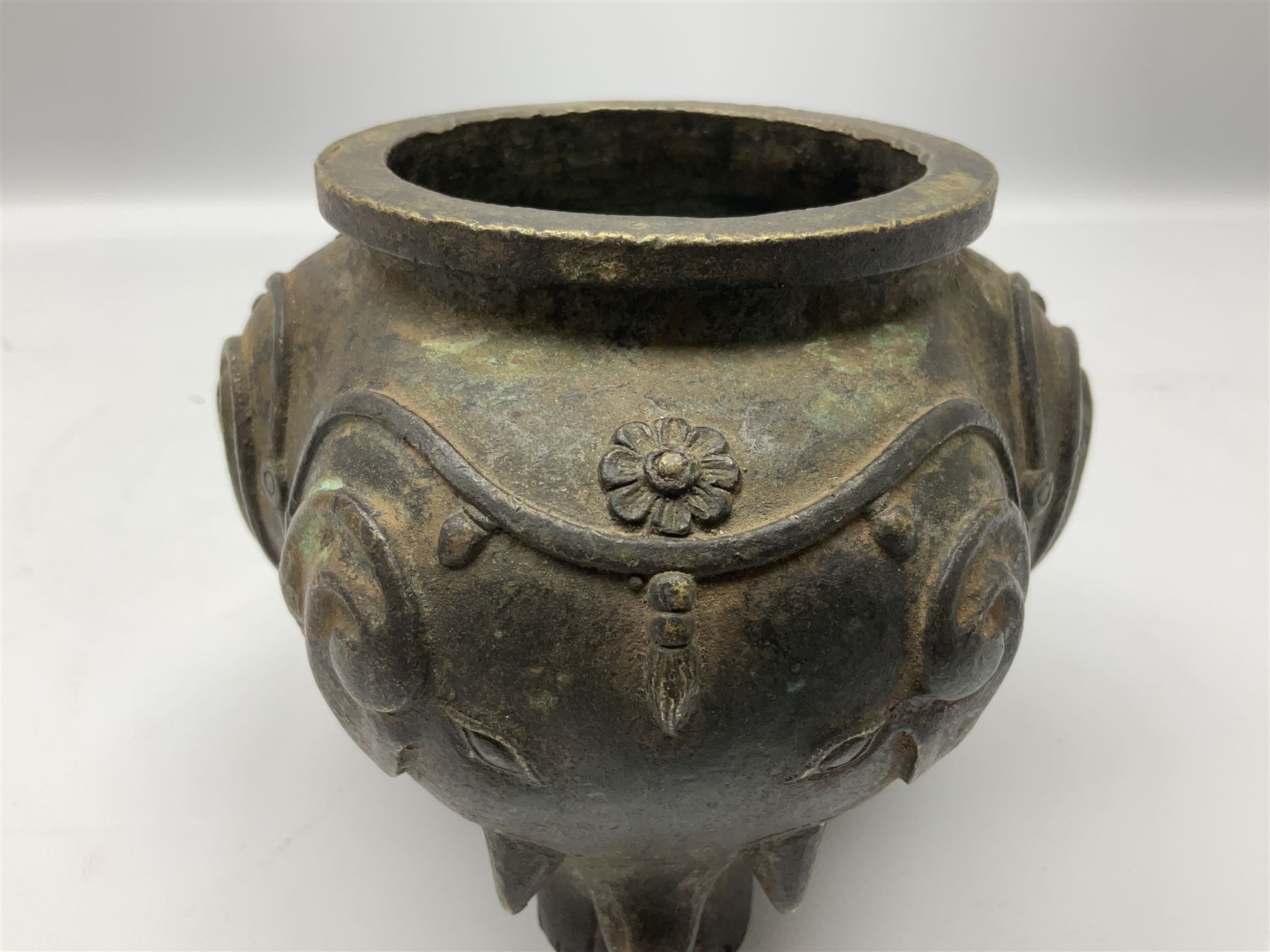 Chinese Qing dynasty bronze elephant censer, of tripod form, the lobed body cast as the heads of three elephants with floral trappings, upon three legs modelled as elephant feet, H12cm rim D9.5cm