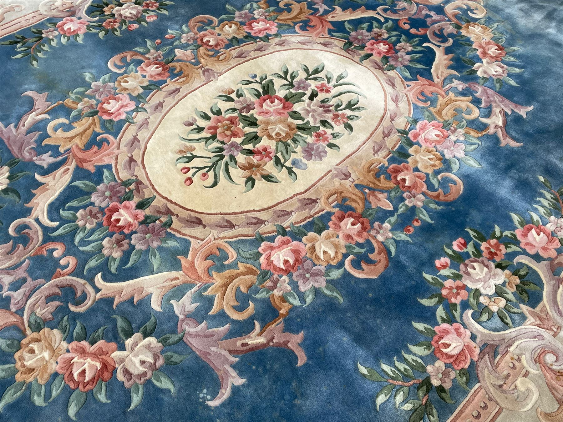 Large Chinese blue ground woollen carpet, overall floral design, central oval medallion surrounded by scrolling floral decoration, wide border with decorated with floral bouquets 