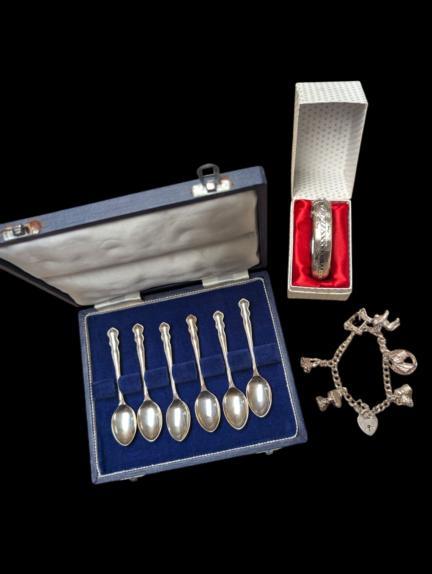 Silver charm bracelet, silver bangle, and cased set of silver spoons, all hallmarked 