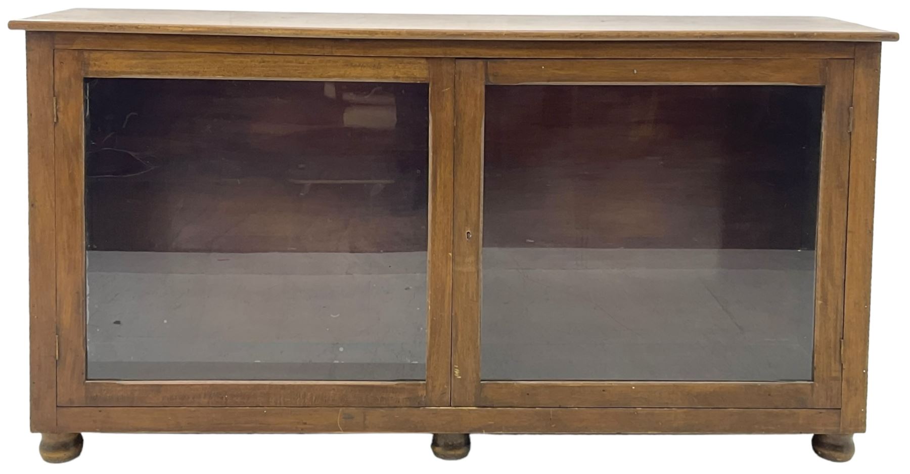 Early 20th century mahogany bookcase, rectangular top over two glazed doors, fitted with four adjustable shelves, on turned bun feet 