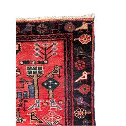 Persian crimson ground runner, the field decorated with stylised tree and animal motifs, indigo ground border decorated with alternating stylised flowerhead and bird motifs 