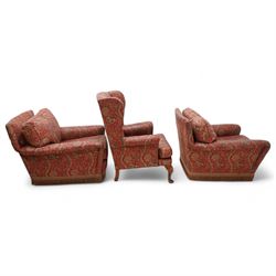 Three-piece lounge suite - pair of armchairs with rolled arms (W85cm, H74cm, D95cm); wingback armchair on cabriole feet (W74cm, H97cm, D73cm), upholstered in crimson ground floral pattern fabric 