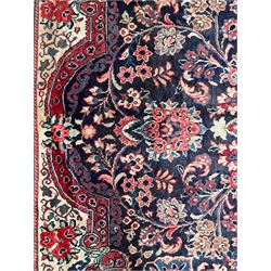 Persian Mahal indigo ground carpet, floral medallion on a field of swirling leafy branches and flower heads, shaped ivory field band decorated with flower head bouquets and trailing branches, the border decorated with floral motifs, within guard stripes