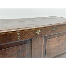 18th century oak coffer, moulded rectangular hinged lid, the frieze rail set with studded initials 'I.M' and engraved brass plate escutcheon, double fielded panel front, lower applied mould, on stile supports