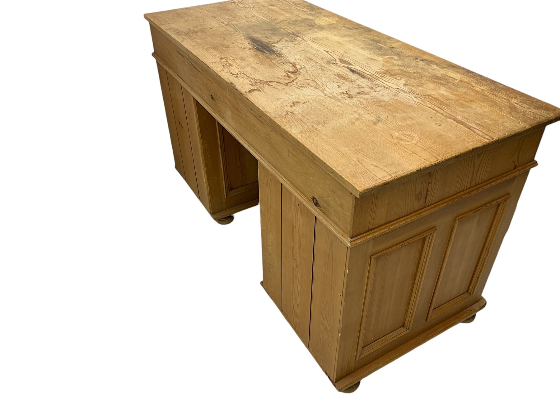 Waxed pine twin pedestal desk, rectangular top over nine drawers, on compressed bun feet 