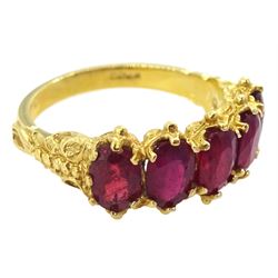 18ct gold five stone oval cut glass-filled ruby ring, with scroll design shoulders, London 2005