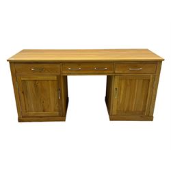 Contemporary light oak twin pedestal desk, fitted with three drawers over two cupboards with chrome handles, the central drawer with hinged front panel revealing pull-out keyboard tray, on plinth base