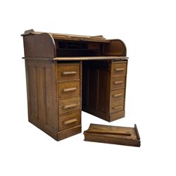 Early 20th century oak twin pedestal desk, tambour roll top enclosing fitted interior, eight drawers, on plinth base