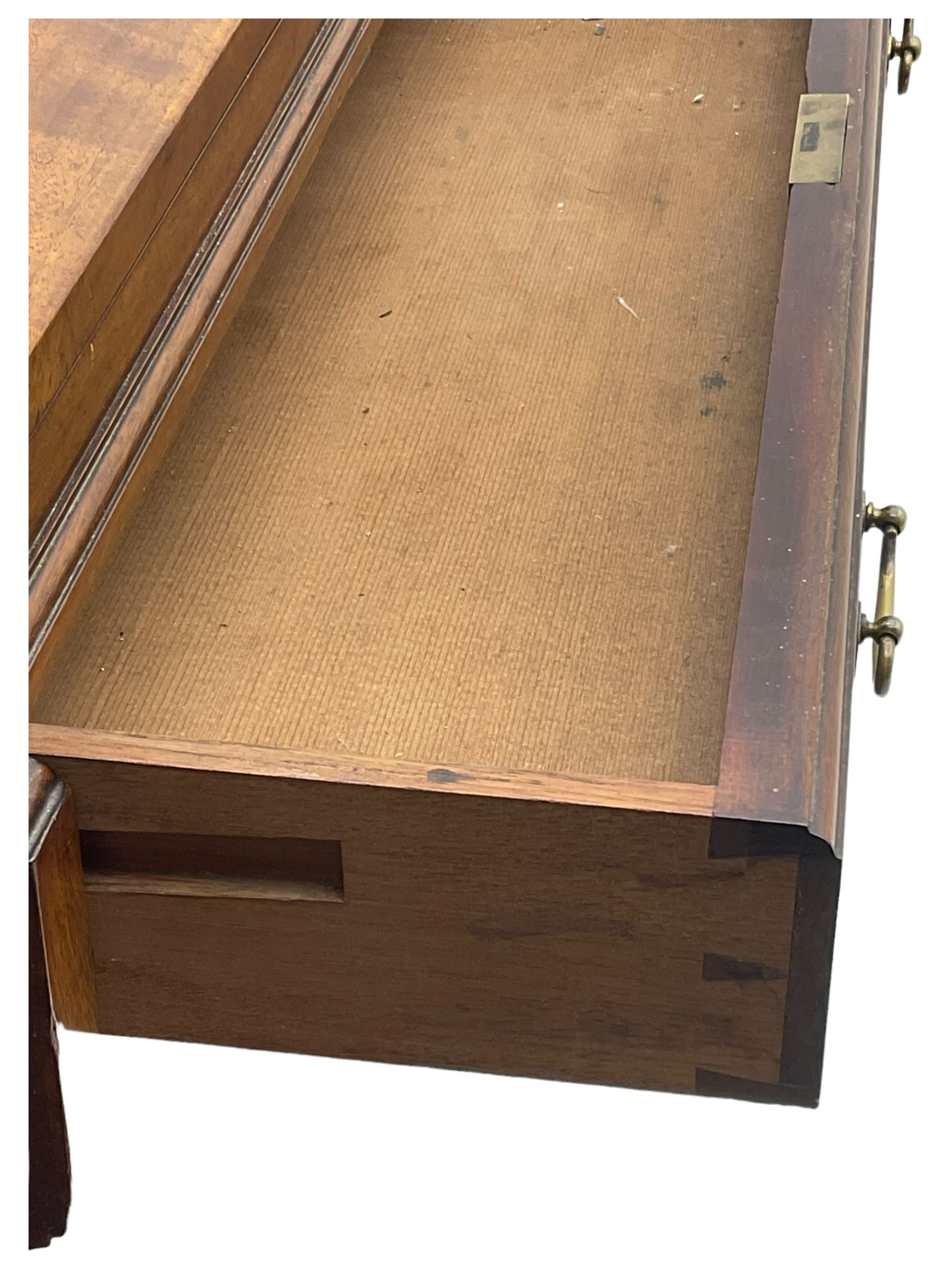 Victorian walnut clerk's desk, raised central section with tambour roll over hinged top, the interior fitted with leather inset writing surfaces, small drawers, document divisions and pen and ink stand, central drawer over double panelled cupboard, flanked by two banks of four graduating drawers, on bracket feet 