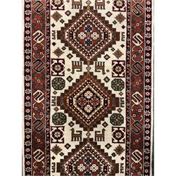 Persian design ivory ground rug, six lozenge medallions within a field of stylised animal and geometric motifs, the guarded border decorated with interconnected S motifs 