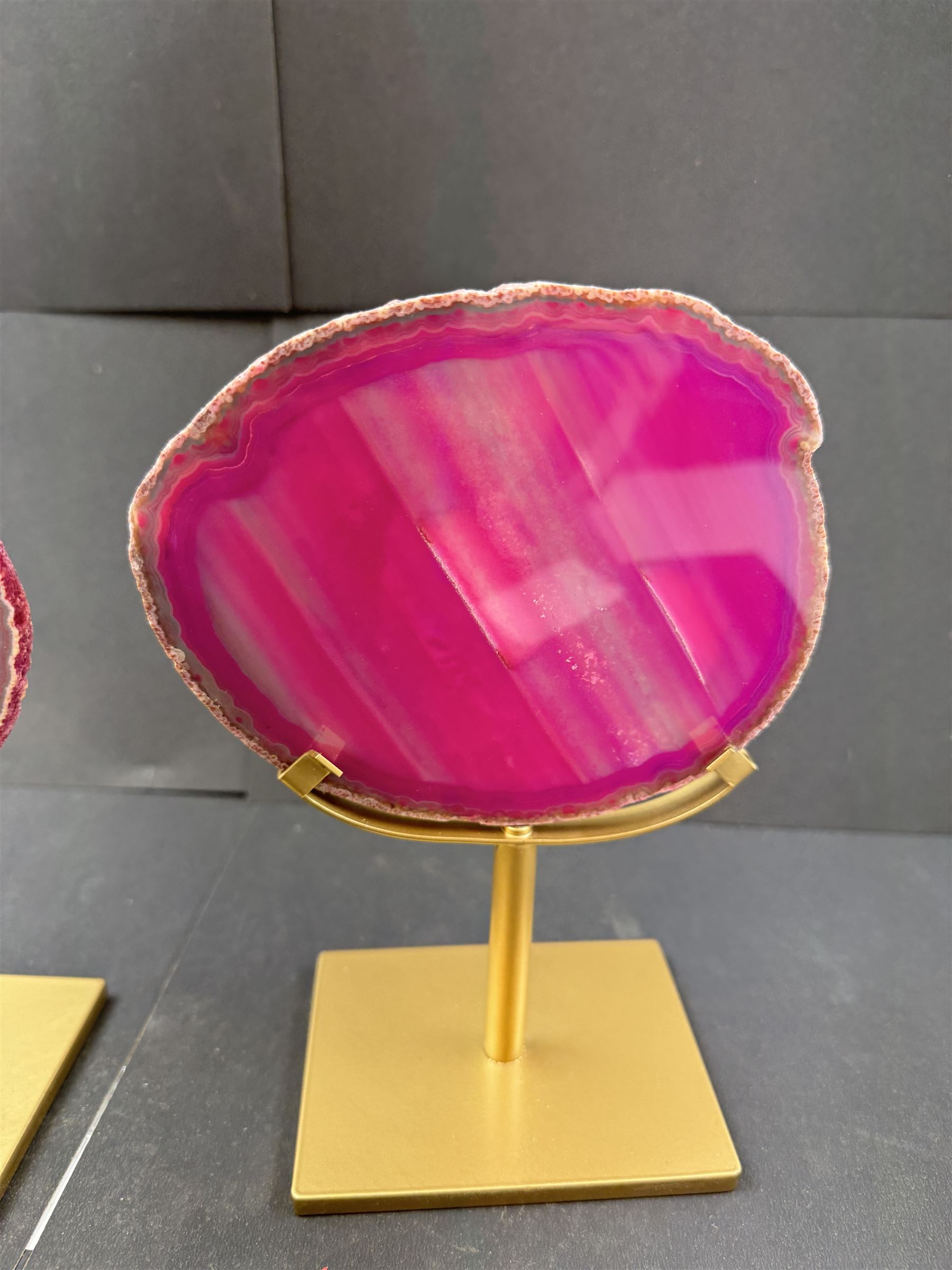 Pair of pink agate slices, polished with rough edges, raised upon gilt metal stands, H20cm