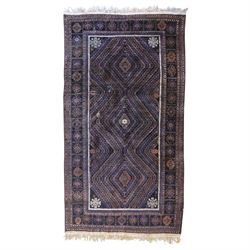 Persian indigo ground rug, decorated with three central lozenges with concentric hooked de...