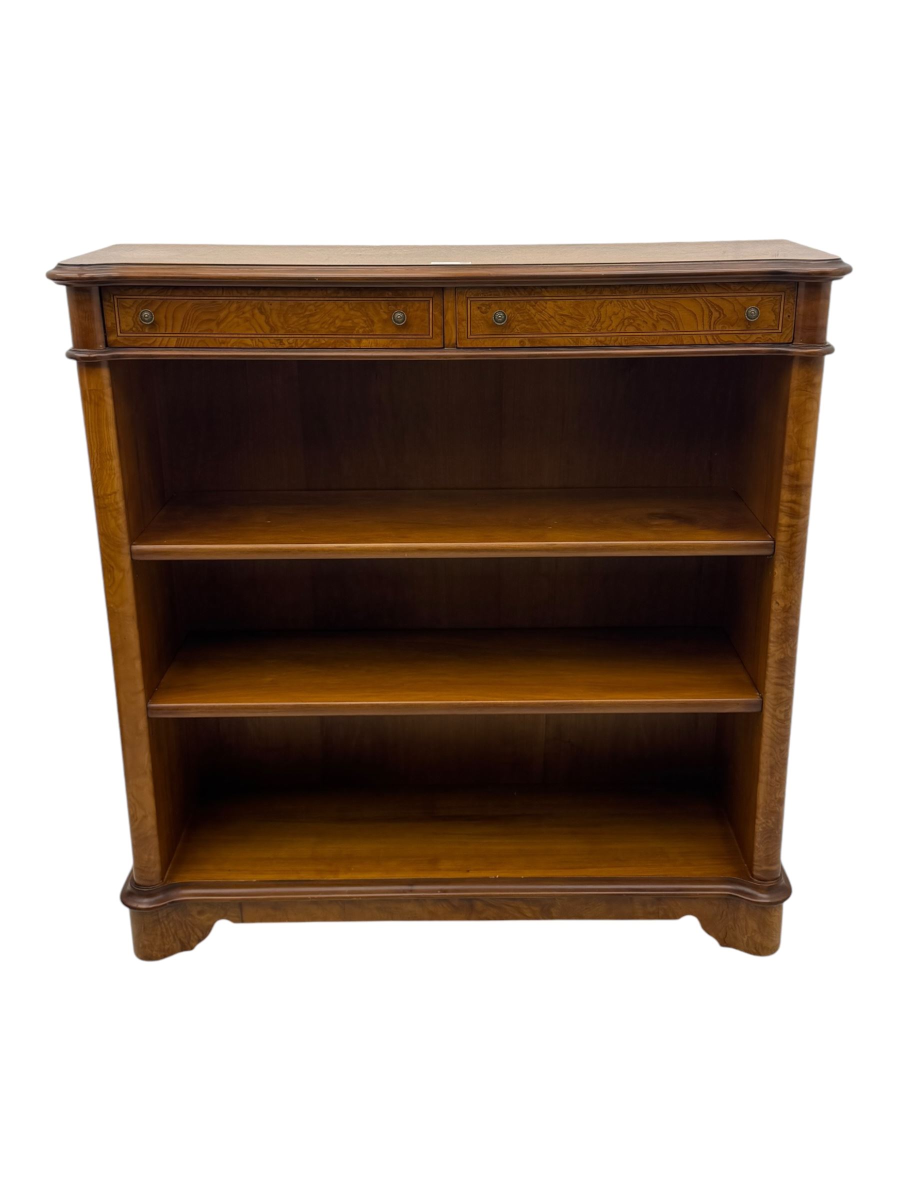 Figured walnut open bookcase, moulded top over two drawers and two shelves, on plinth base 