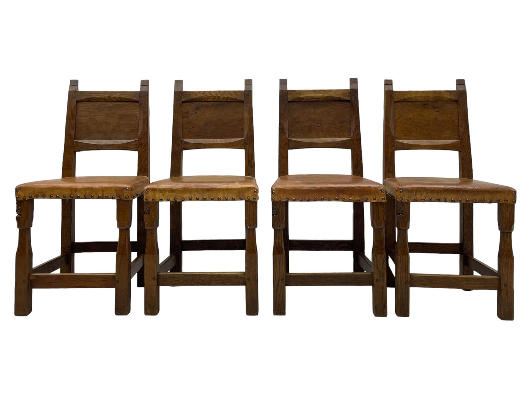 Gnomeman - set of eight (6+2) oak dining chairs, adzed panelled back over tan leather upholstered seat with applied stud band, on square supports united by plain stretchers, each chair carved with gnome signature, by Thomas Whittaker, Littlebeck, Whitby