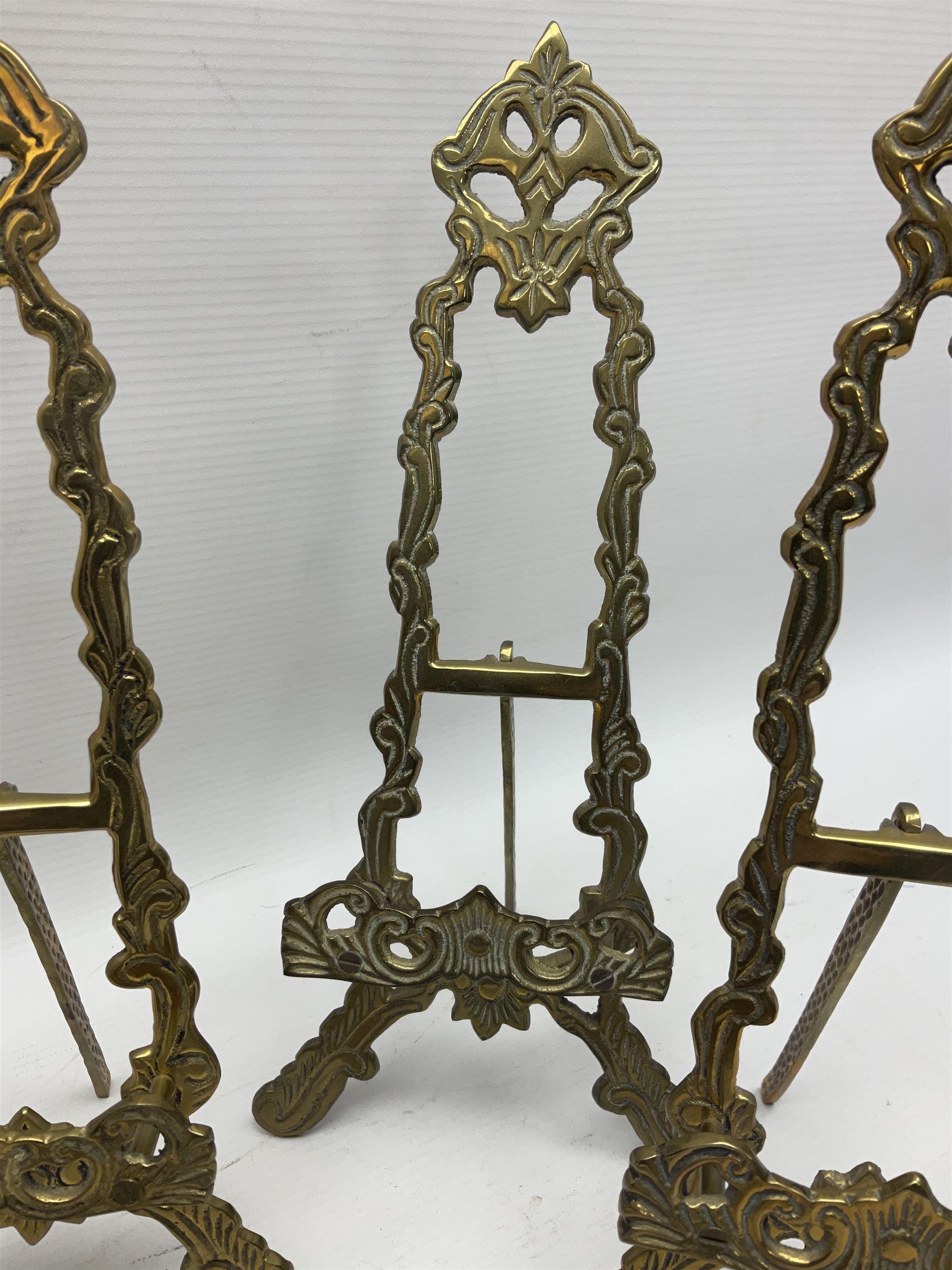 Set of six ornate cast brass easel stands, H30cm