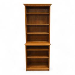 Light oak two-sectional bookcase, projecting moulded cornice over five adjustable shelves, carved with oak leaf motif 