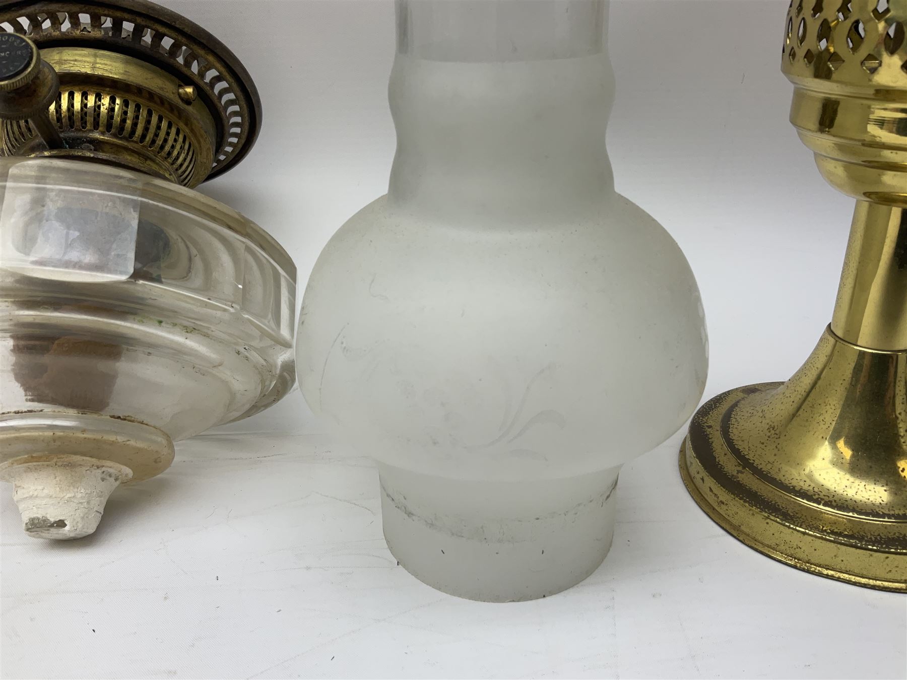 Victorian brass oil lamp converted to electricity, the square stepped base with a reeded doric column leading to a cut clear glass reservoir and burner and spherical shade with printed bird decoration, together with another similar shade and oil lamp parts and accessories etc