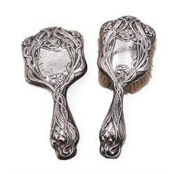 Art Nouveau silver mounted two piece dressing table set, comprising hair brush and hand mirror, each heavily embossed with naturlistic florals and engrved with monograms, hallmarked Walker & Hall, Sheffield 1907