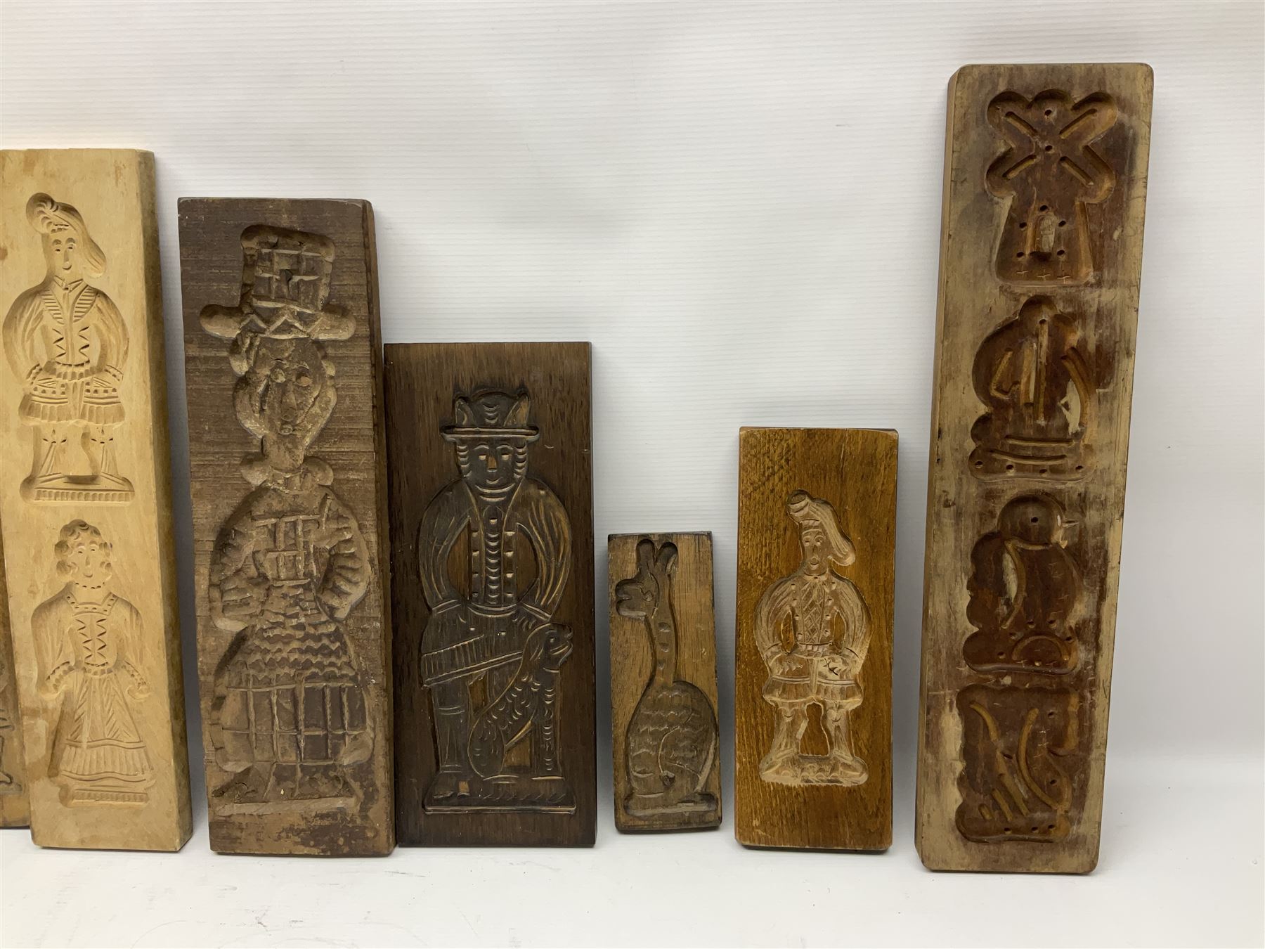 Collection of 20th century beech and other hardwood Dutch folk art Speculaasplank or biscuit moulds, most examples typically carved with figures in traditional dress, tallest H52cm